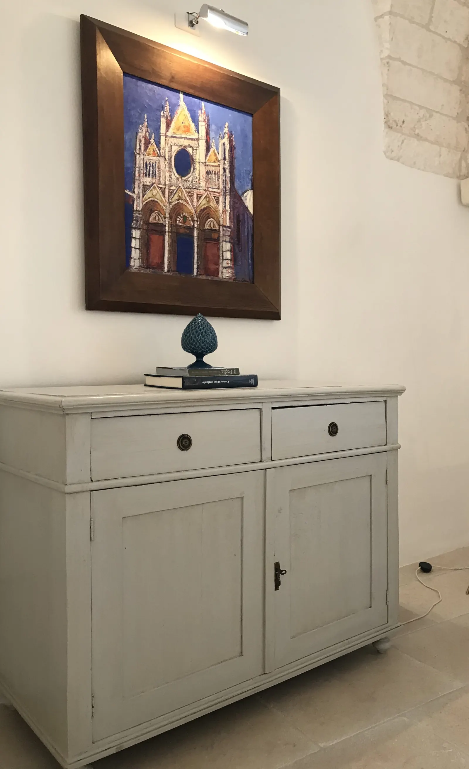 Painted cabinet below a picture of the cathedral