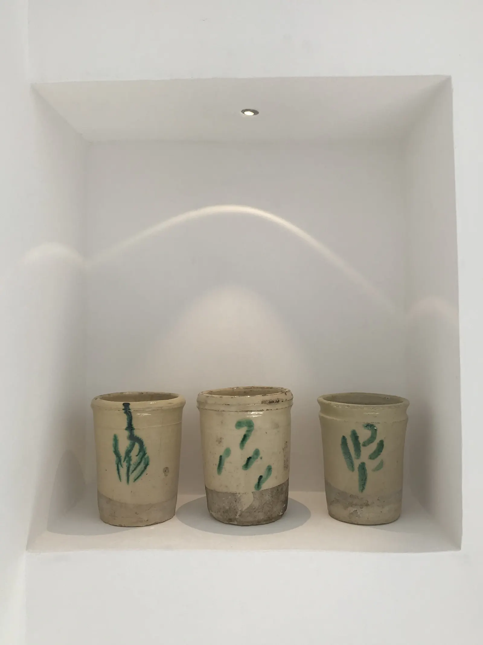 Ceramic pots in a lit wall niche