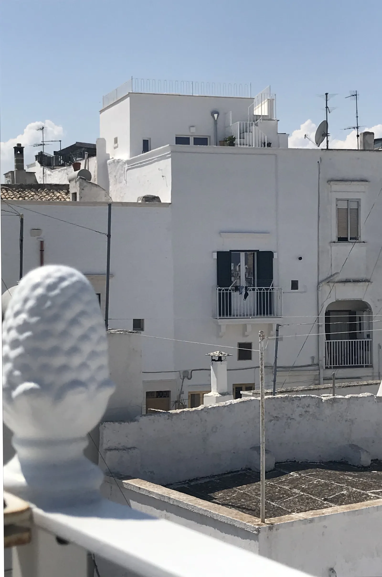 Whitewashed rooftops and a stone pine cone ornament