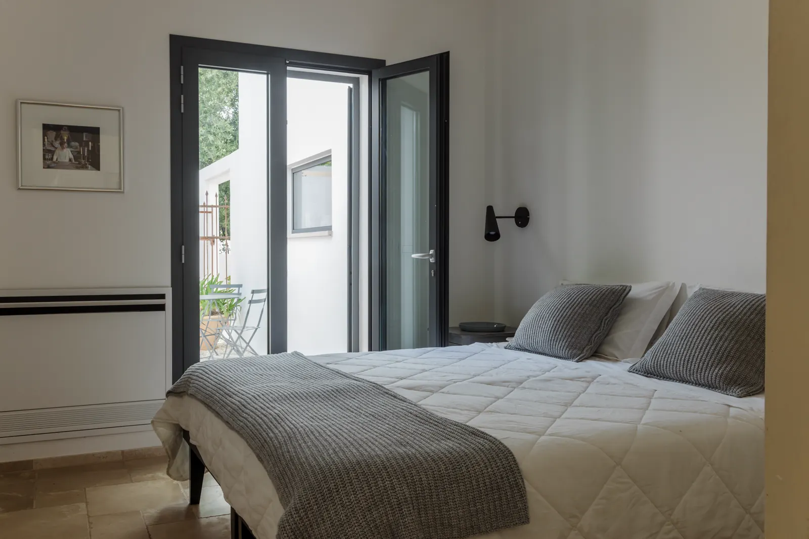 Master bedroom with doors opening onto a private balcony