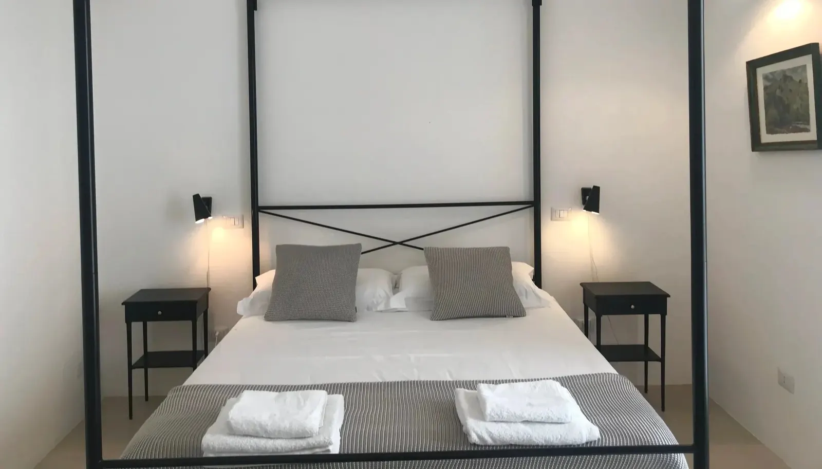 Casa Mima bedroom with a four-poster bed and bedside lamps