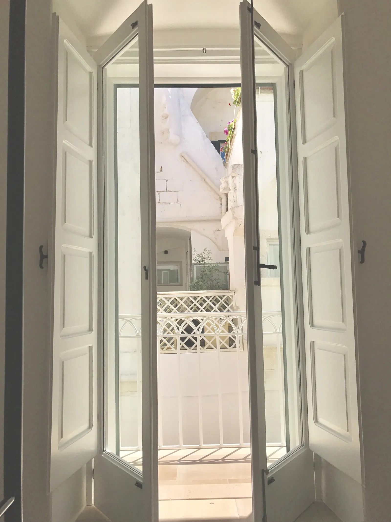 Balcony doors open to the palazzo opposite