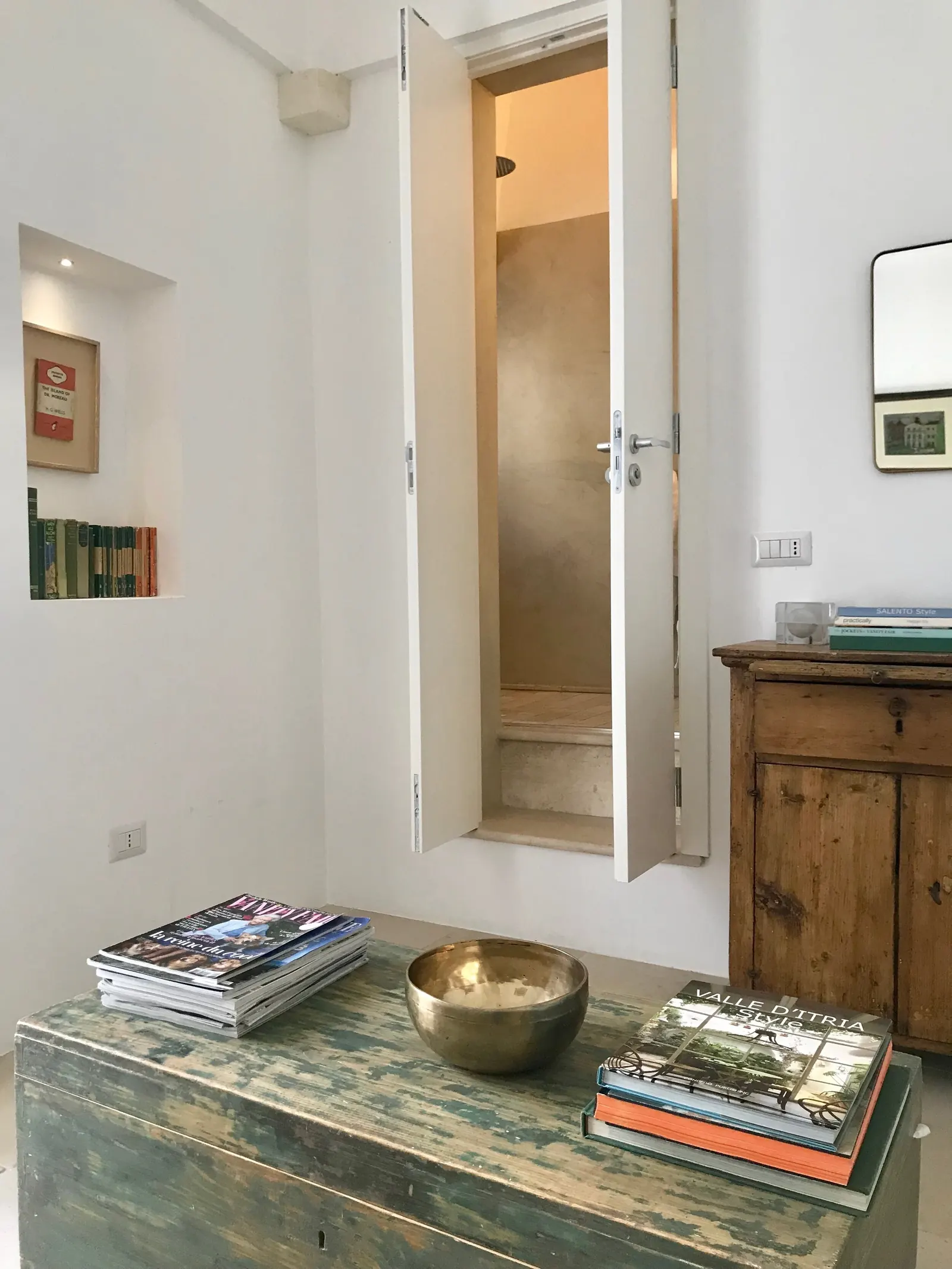 Books and a bowl on a chest by the window
