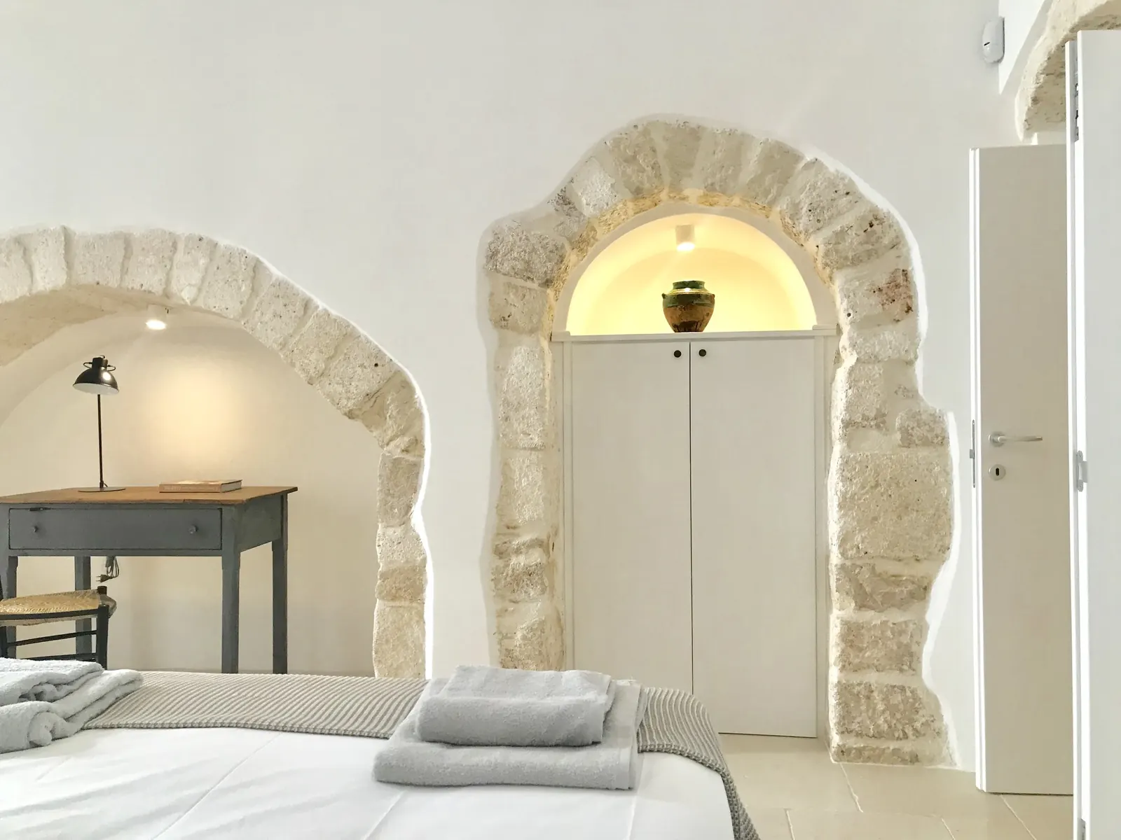Bedroom with stone arch and wardrobe