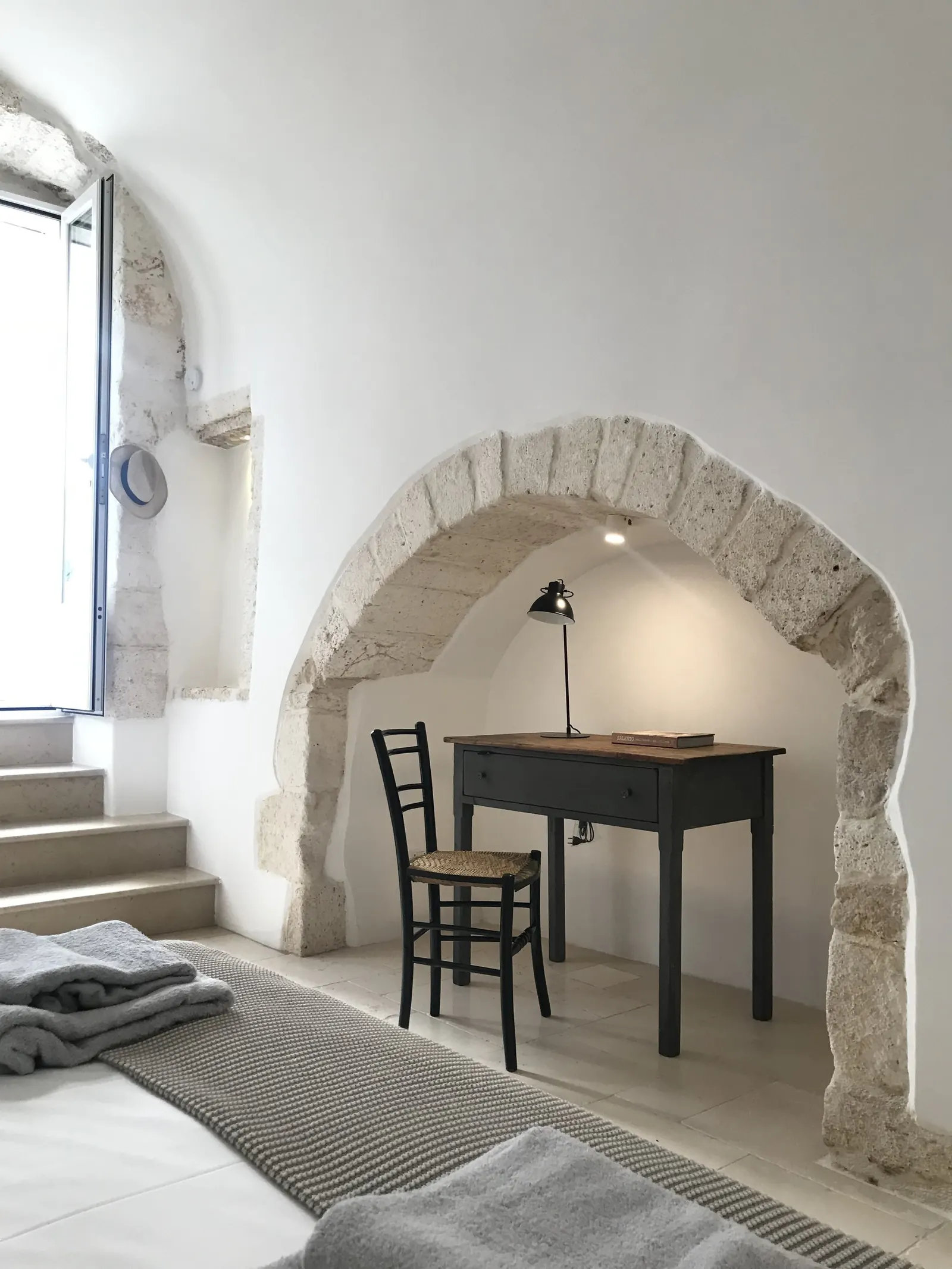 Desk and bed beneath the stone arch