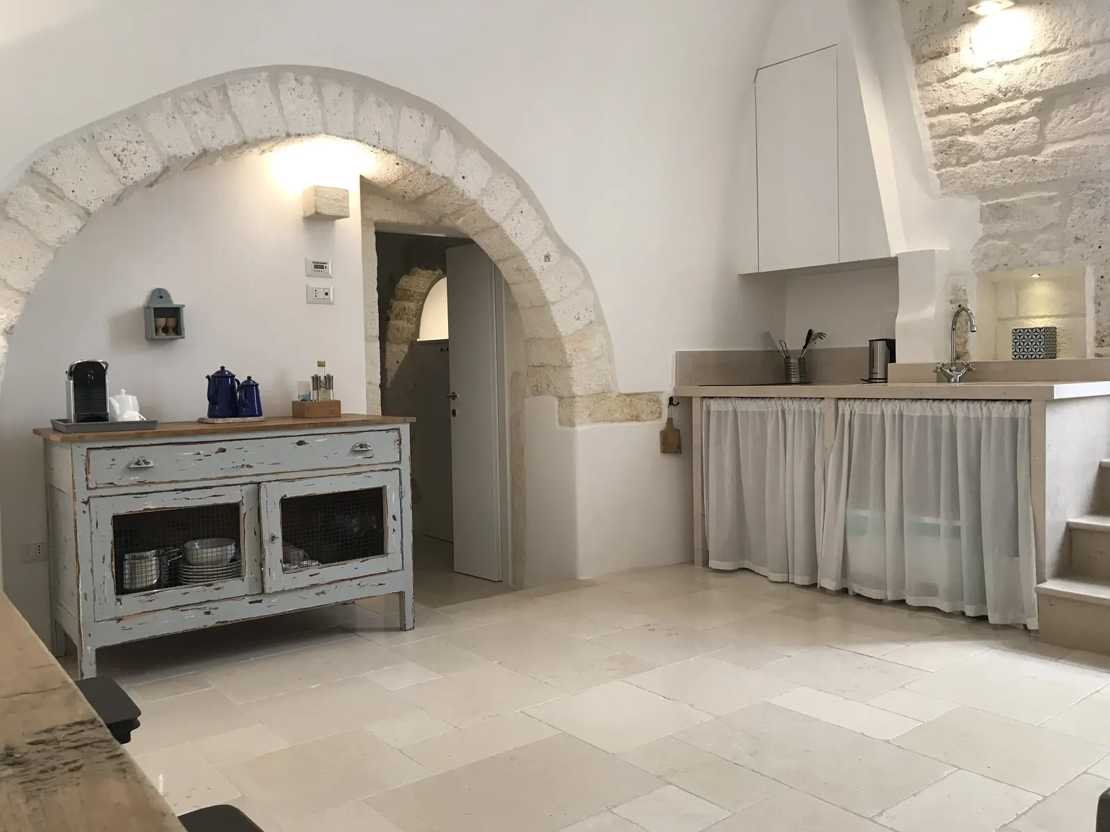 Kitchen and painted dresser under a stone arch