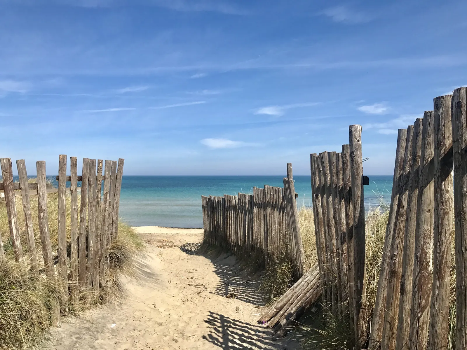 Weathered wooden fences on a path to the beach